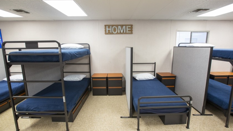 Empty shelter beds and a sign that reads "home"