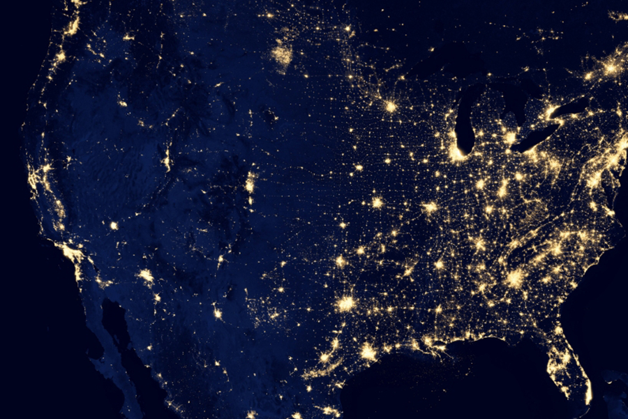 Satellite image of the United States at night, illuminated by a network of electric lights