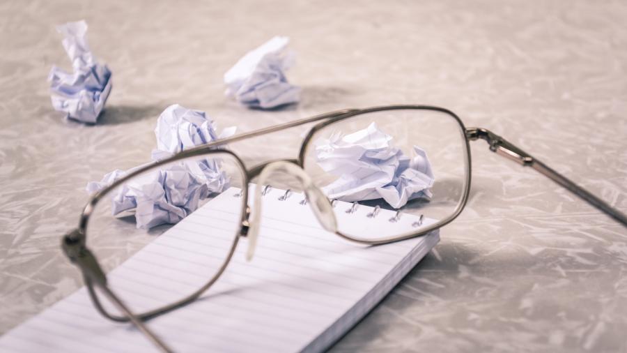 Glasses next to a crumpled piece of paper