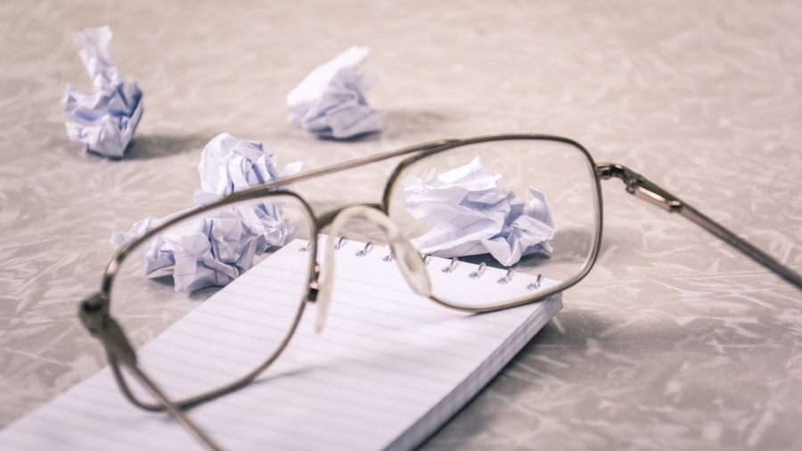 Glasses next to a crumpled piece of paper