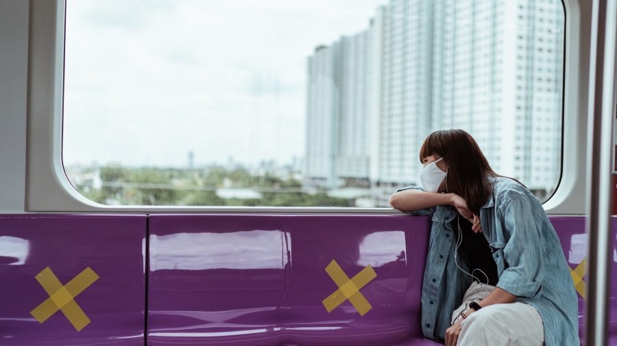 A woman wearing a face mask on a train