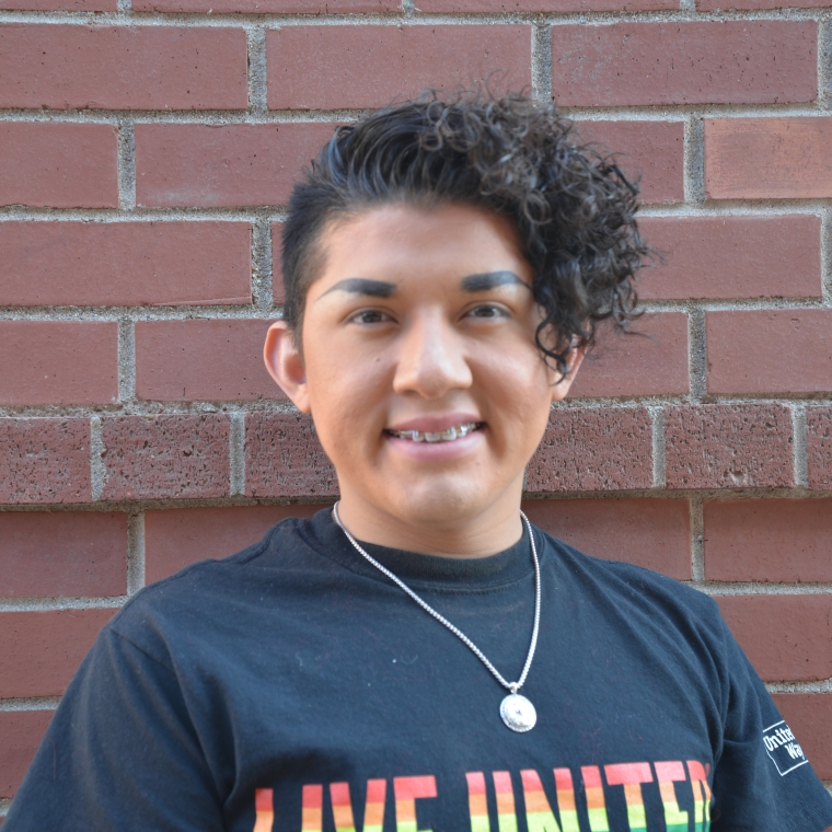 Adonias Arevalo smiling in front of a brick wall