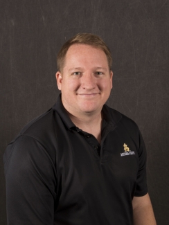 Joshua Loughman smiling in a black polo